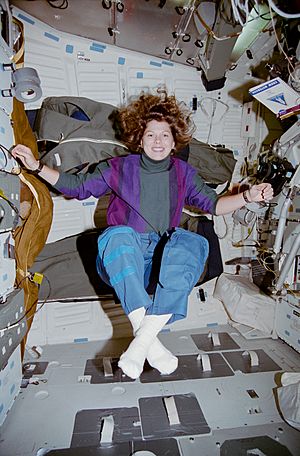 STS070-335-006 - Weber floats in the middeck in a yoga position (Retouched)