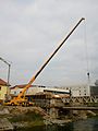Truck-mounted crane building a bridge