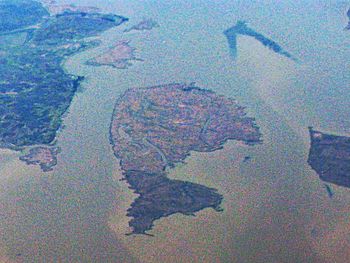 A grainy aerial photo of numerous small islands surrounded by water.