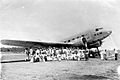 COLLECTIE TROPENMUSEUM Een groep Europeanen staat op het vliegveld Rambang voor het vliegtuig de Uiver dat is aangekomen op Lombok na afloop van de London-Melbourne-race in 1934 TMnr 10010712