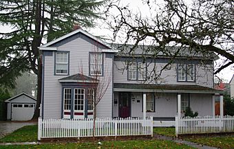 Photograph of the Blank house, a two-story, pedimented house with a large bay window and low-elevation porch