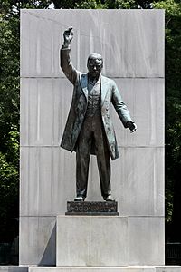 Statue of Roosevelt holding an arm up during an oration