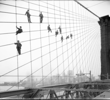 Painters suspended on cables of the Brooklyn Bridge, on 07 October 1914