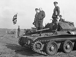 Winston Churchill stands on a Covenanter tank of 4th-7th Royal Dragoon Guards, to take the salute at an inspection of 9th Armoured Division near Newmarket, Suffolk, 16 May 1942. H19765