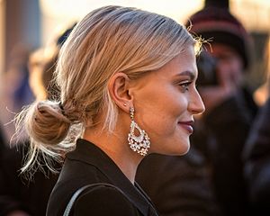 Side view of smiling Fallon in a black jacket with her hair tied back.