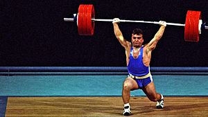 A man in a blue leotard lifting weights.