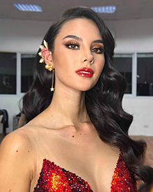 Catriona Gray with iconic tristar and sun earpiece, in Mak Tumang Swarovski gem-embellished "Mayon" evening number