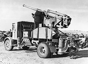 An Italian 90-53 gun on a truck mounting joining the rows of derelict Axis vehicles and equipment jettisoned by Rommel's army