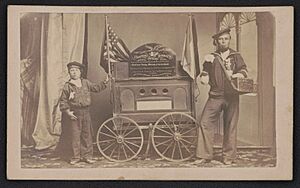Bernard Tobey, a double amputee and his son, wearing Union sailor uniforms, standing beside a small wagon displaying Secretary of War Edwin Stanton's dispatch on the fall of Fort Fisher) - LCCN2017659614