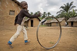 Boy playing with a hoop in the streets of Pinga, RDC