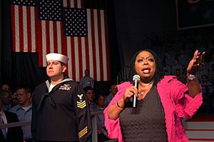 US Navy 070221-N-7883G-020 Singer and performer Carol Woods sings to service members in the hangar bay aboard USS Kitty Hawk (CV 63) prior to the visit by Vice President Dick Cheney.jpg