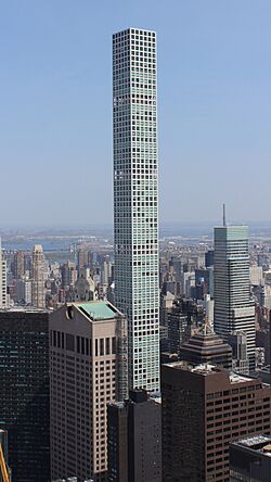 The middle stories of 432 Park Avenue, as seen from the observation deck of another building several blocks away. 432 Park Avenue is a thin tower with a square floor plan. The white facade has square windows.