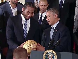 Kawhi Leonard presents ball to President Obama 2 2015-01-12 cropped