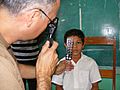 US Navy 090402-N-1580K-710 Navy optometrist Cmdr. Louis Perez uses a retina scope and lens rack to check the eyes of 9-year old Sergio Colochos during the Beyond the Horizon humanitarian assistance exercise in Honduras