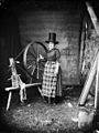 A woman in "Welsh national" dress with a spinning wheel NLW3361179