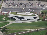 Aerial view of round white museum with grassy roof and grounds