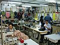 People at sewing machines in a small garment factory