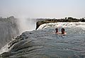 Tourists swimming at Victoria Falls