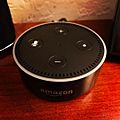 Amazon Echo Dot (black) on a wood surface
