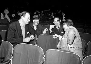 John Wayne, Maurice Chevalier, Anthony Quinn and Jerry Wald during 1958 Academy Awards rehearsals.jpg