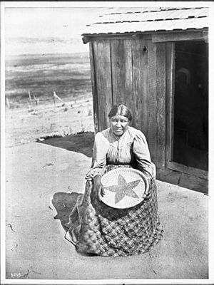Ramona Lubo, wife of Alesandro, at her home, showing the star basket she made in his memory, ca.1905 (CHS-3875)