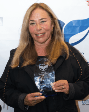 A candid shot of Susan Seidelman holding a lifetime achievement award from Mystic Film Festival