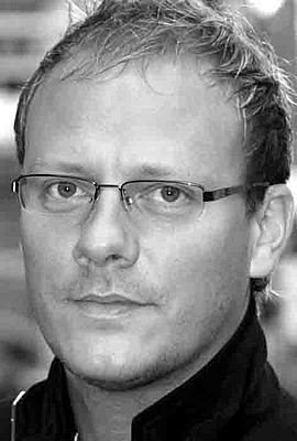 Greyscale photograph of a blond man with glasses