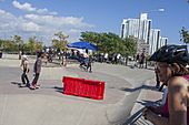 Sam Sneed kickflips over a red barrier at Far Rockaway Skatepark