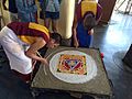 Buddhist Monks performing traditional Sand mandala made from coloured sand