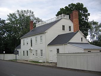 Back side of a two-story, white, clapboard house