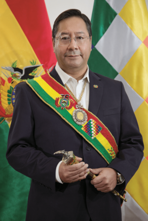 Luis Arce in the Casa Grande del Pueblo, invested with the symbols of command. Behind are the dual flags of Bolivia: the national flag and the Wiphala.