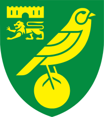 Badge of Norwich City: a green shield with yellow emblems. A bird (canary) on top of a ball as the main image, and a castle above a lion passant guardant in the top left quarter.