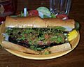 Choripán sandwich with green chimichurri sauce
