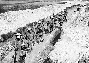 Men of the King's Liverpool Regiment carrying barbed wire picket posts along a communication trench near Blairville Wood, 16th April 1916. Q525