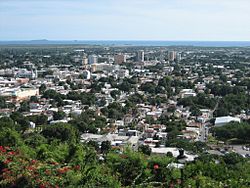 Partial view of the city of Ponce in 2006, as seen from Cerro del Vigía, with the Caribbean Sea and Caja de Muertos in the background