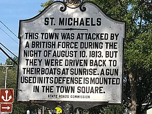 A sign that says: This town was attacked by a British force during the night of August 10, 1813, but they were driven back to their boats at sunrise. a gun used in its defense is mounted in the town square.