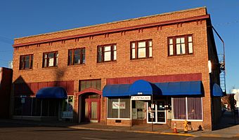 Photograph of a two-story brick building on a street corner