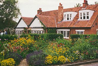 Two-floor, brick suburban house set within a garden