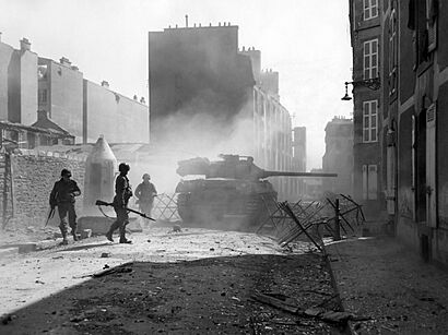 M18 tank destroyer fires its 90mm gun point-blank at a Nazi pillbox emplacement to clear a path through a side street in Brest, France. September, 1944. (49811749312)