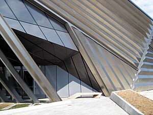 The entrance of the Eli and Edythe Broad Art Museum, highlighting the complex angles of the building and movement from the stainless steel pleated exterior and layered concrete arches.