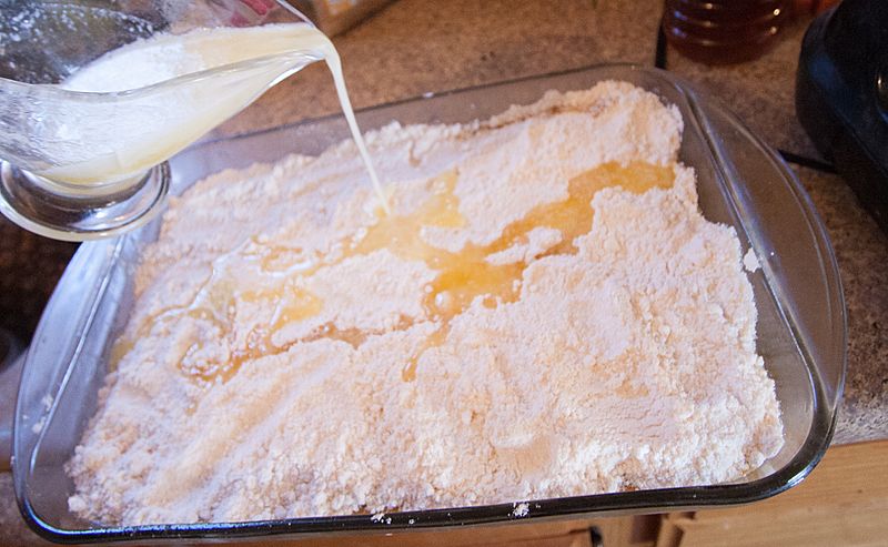 Pumpkin dump cake pouring butter