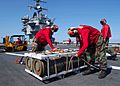 US Navy 030830-N-6187M-001 Sailors remove a hoisting sling from an ammo crate carrying 2000-pound Mark 84 general purpose bombs