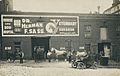 Scene of men standing, seated in automobiles, and in horse-drawn carriages, in front of Dr. Herman F. Sass' veterinary clinic in Toledo, Ohio in approximately 1911.