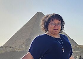 Bradford, a light-skinned Black woman with short, curly hair in front of a pyramid on the Giza Plateau.