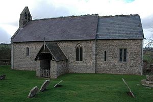 A small simple church seen from the south, with thin windows, a porch, a bellcote at the west end, and a short chancel