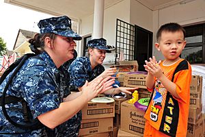 US Navy 110906-N-TO930-085 Sailors make shapes out of Play-Doh with a resident of the Rumah Juara children's home
