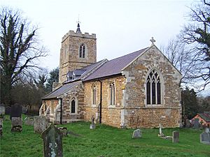 A stone church seen from the southeast with a south porch and a battlemented tower with a spirelet and weathervane