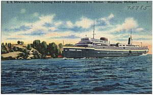 S. S. Milwaukee Clipper passing sand dunes at entrance to harbor, Muskegon, Michigan