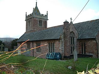 Reddish stone church with square tower.