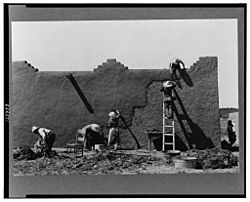 Remudding an adobe wall in Chamisal, circa 1940. Photo: Russell Lee